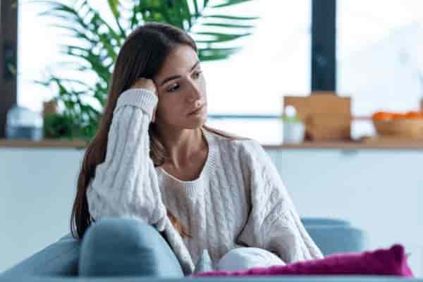 Femme pensive représentant une réflexion sur la vie intime et émotionnelle, accompagnement par une sexothérapeute spécialisée dans le désir féminin.